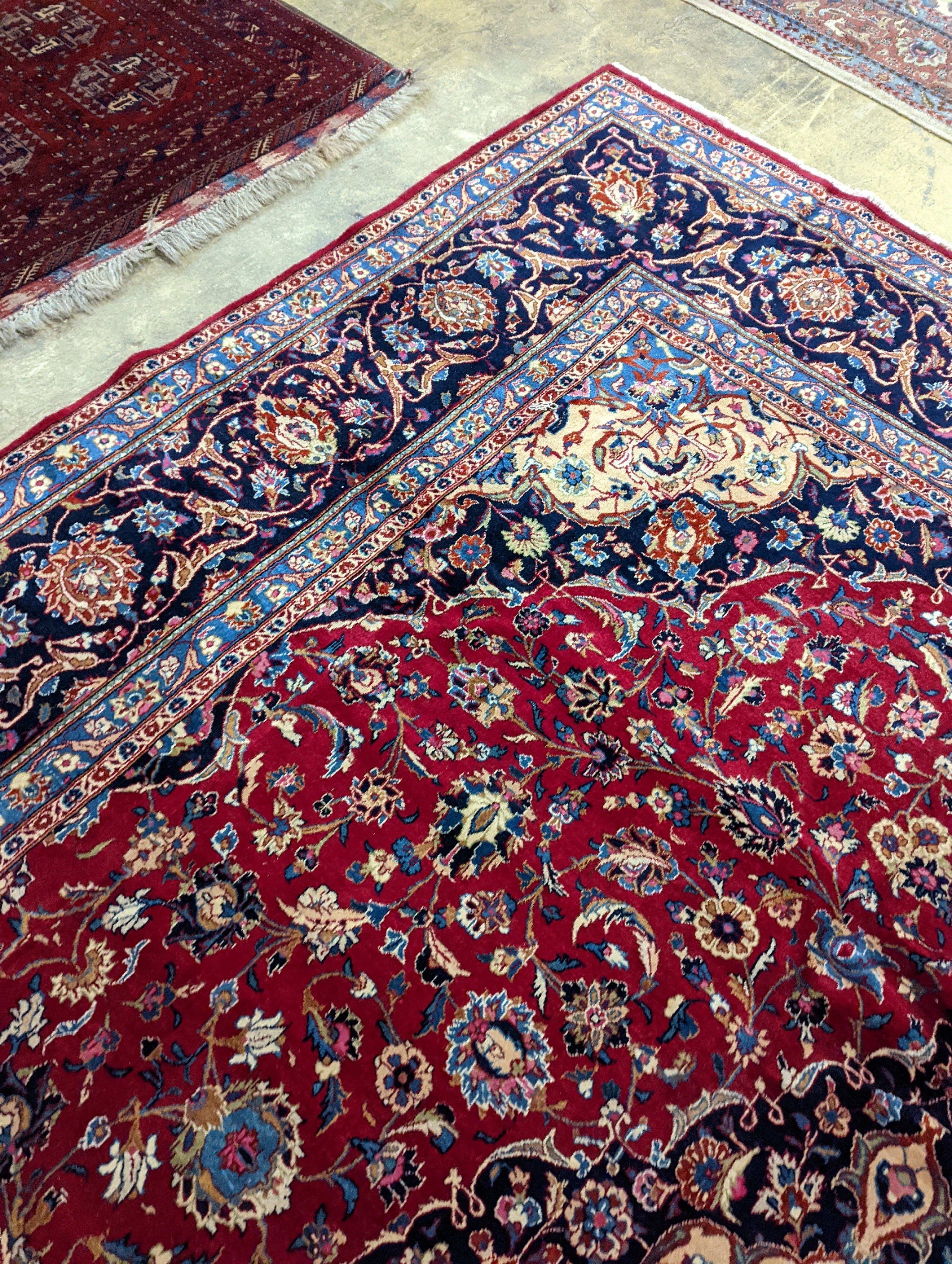 A Kashan burgundy ground carpet, 380 x 300cm